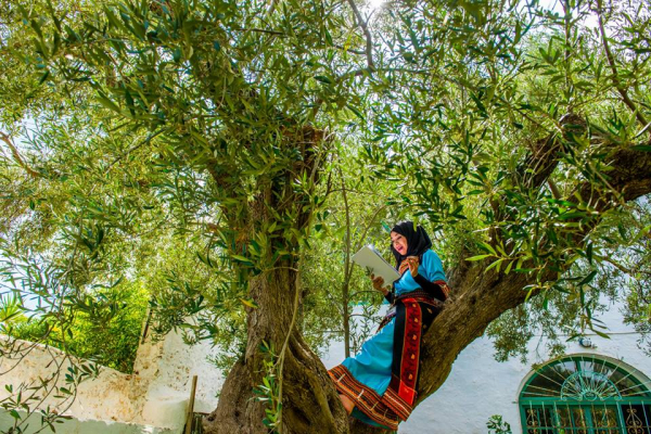 Fadhila Bechar reads in a tree